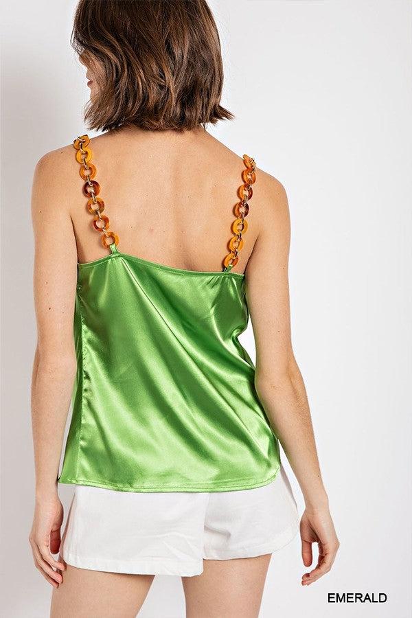 Woman wearing an emerald cowl neck satin camisole with chain strap, paired with white shorts, back view.