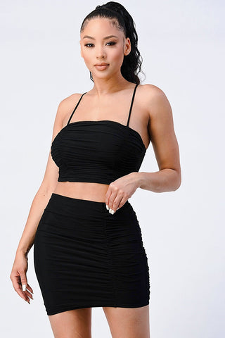 Black mesh cropped cami and skirt set with spaghetti straps, showcasing a chic and sexy two-piece outfit made of soft, stretchy fabric.