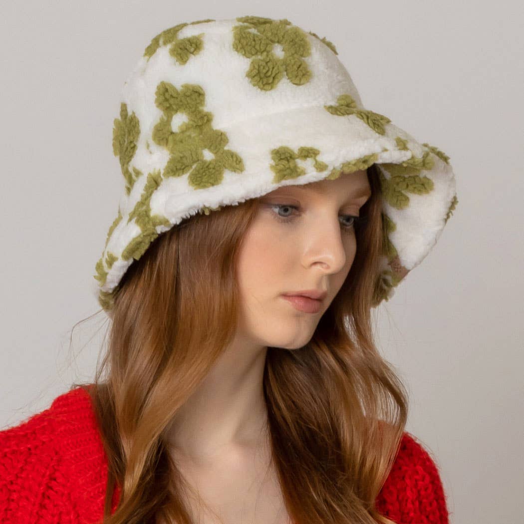 Woman wearing green floral pattern sherpa bucket hat with flat top and adjustable strings, perfect for winter coziness.