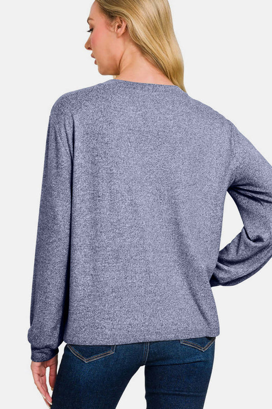 Woman wearing light navy hacci round neck long sleeve T-shirt, showcasing back view and slightly stretchy fabric.