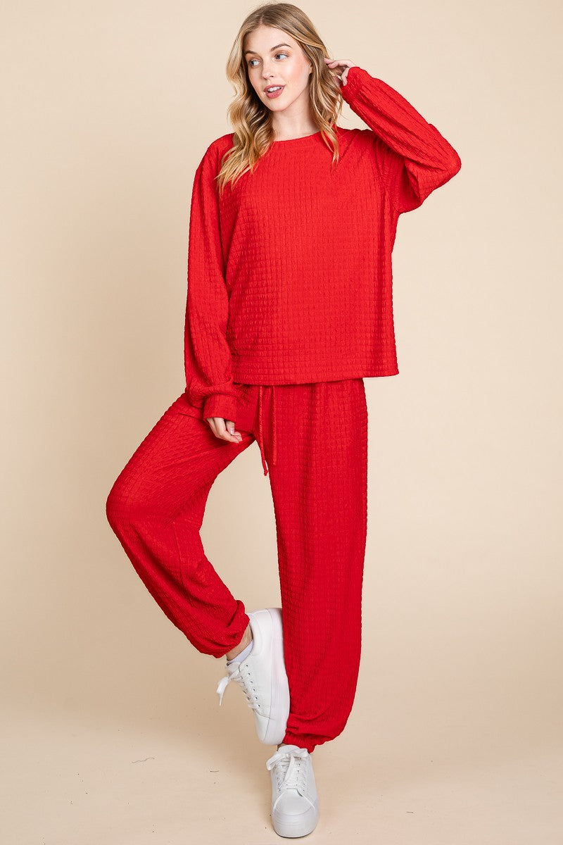 Red full-size crinkle check lounge set with round neck top and pants, featuring a drawstring and slightly stretchy material.