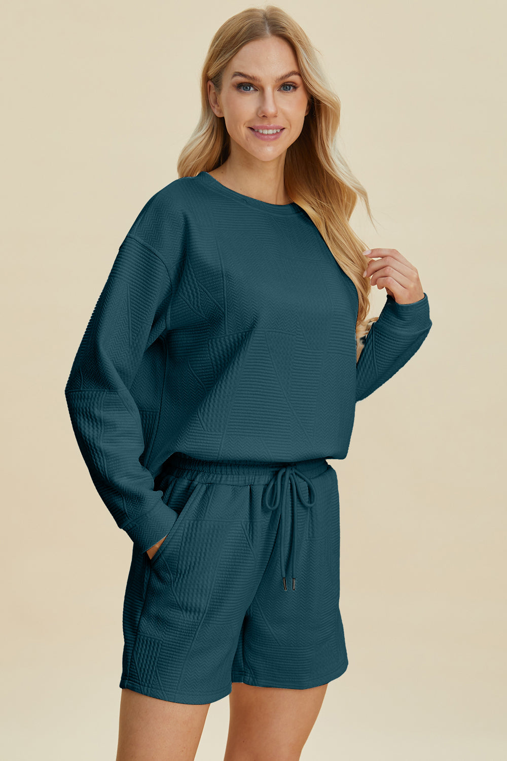 Woman wearing a fall full-size textured long sleeve top and shorts set with drawstring, slightly stretchy, 98% polyester, 2% elastane.