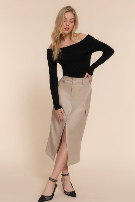 Woman wearing beige midi cargo skirt with side slit and black off-shoulder top, styled with black heels.