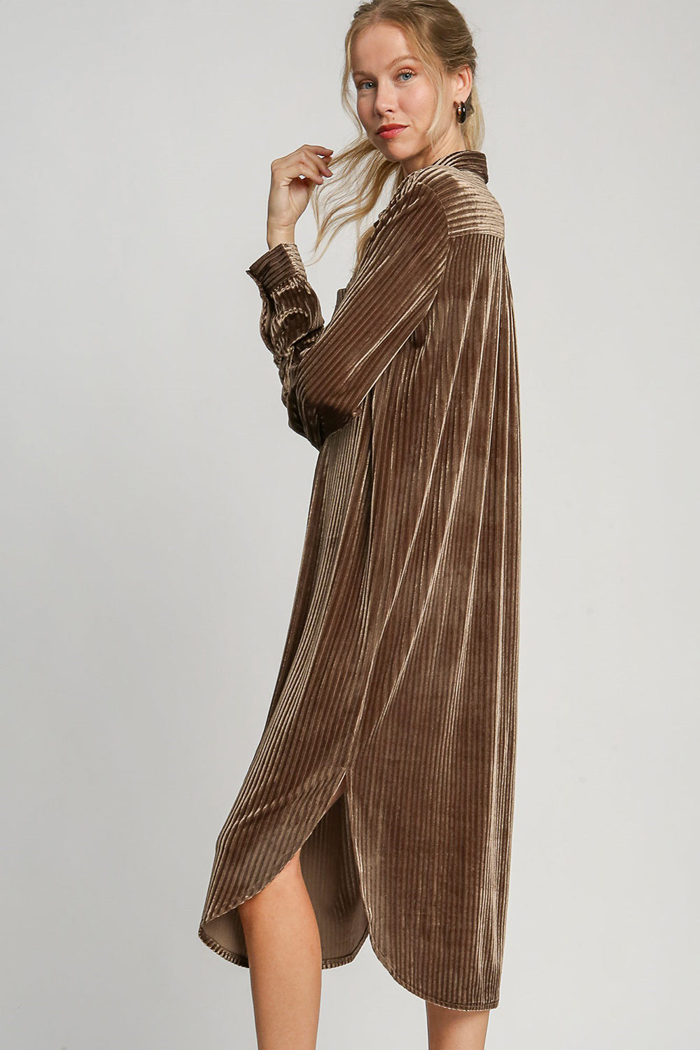 Woman wearing brown textured curved hem button-down shirt dress with slit and slight stretch, made of polyester and spandex.