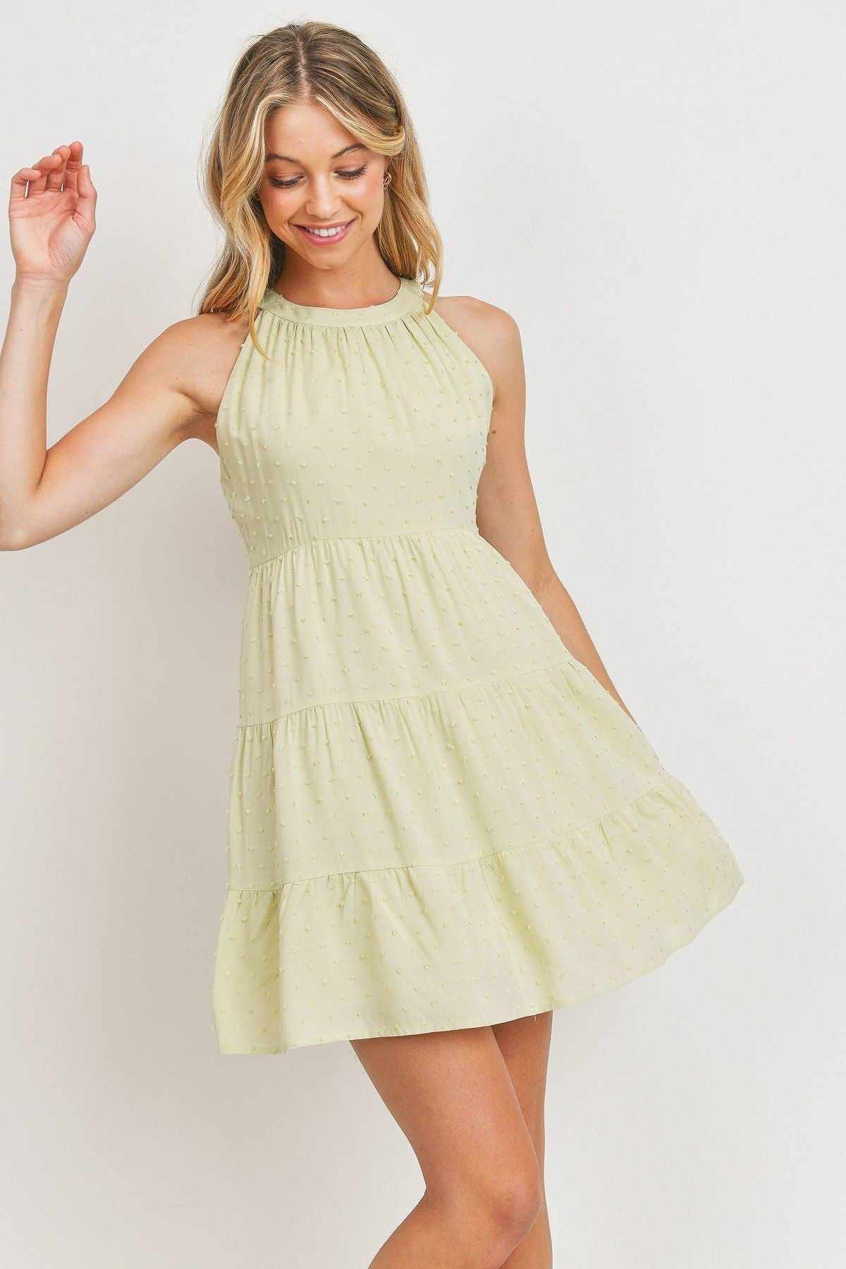 Sage roundneck sleeveless dress with dotted swiss pattern, halter neck, back-keyhole, and three-layered mini hemline.