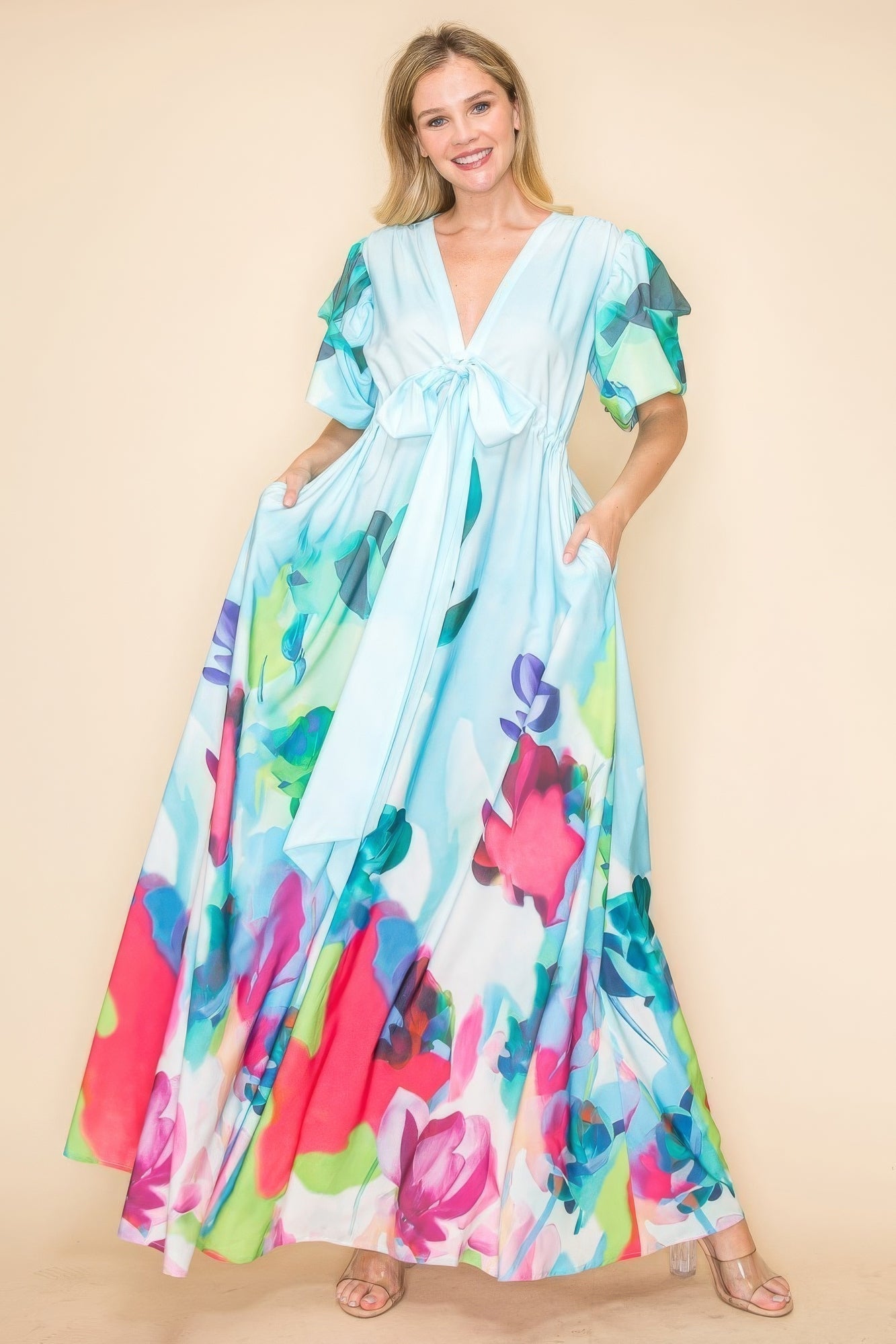 Woman wearing a vibrant multi-color printed V neck maxi dress with a self-tie ribbon and convenient pockets, perfect for casual outings.