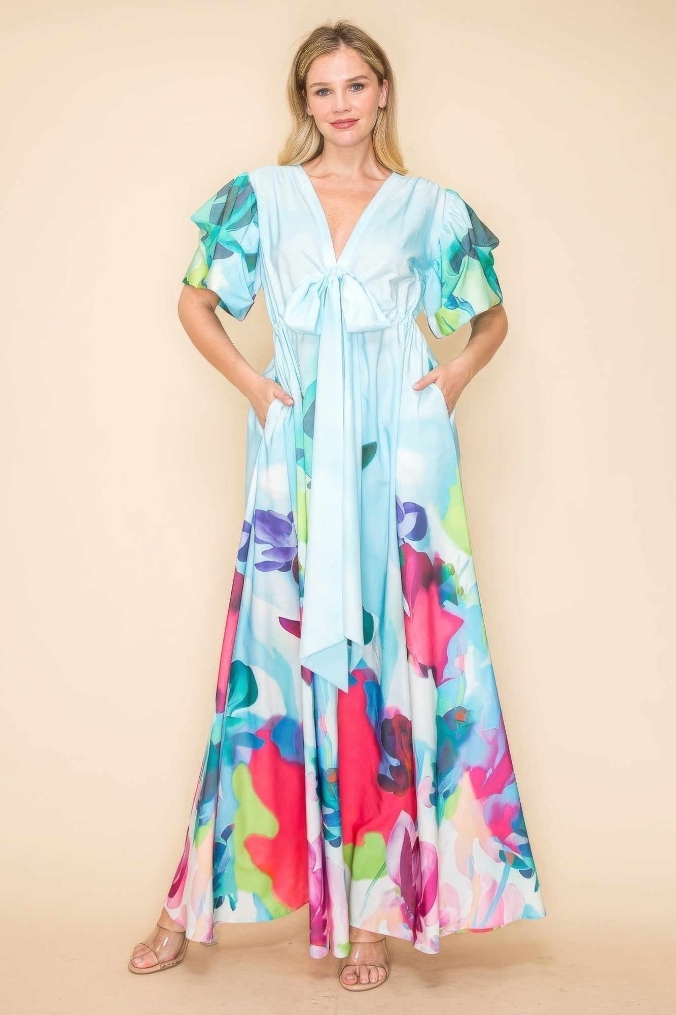 Vibrant multi-color printed V-neck maxi dress with self-tie ribbon and pockets, showcasing a flowy skirt and comfortable fit.