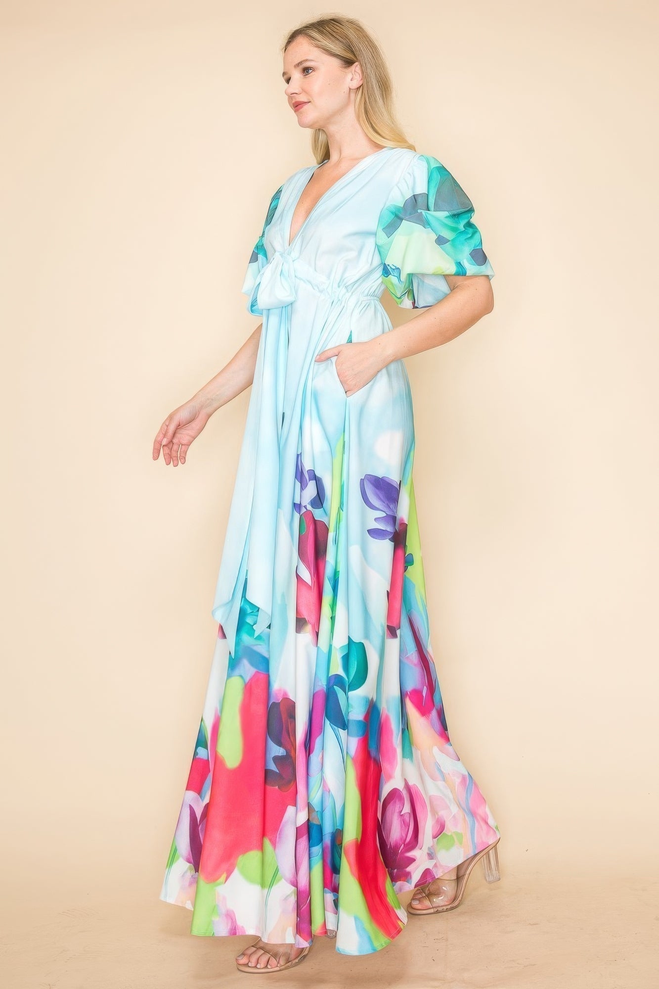 Woman wearing printed V neck maxi dress with vibrant multi-color floral design, accentuating a chic and comfortable look.