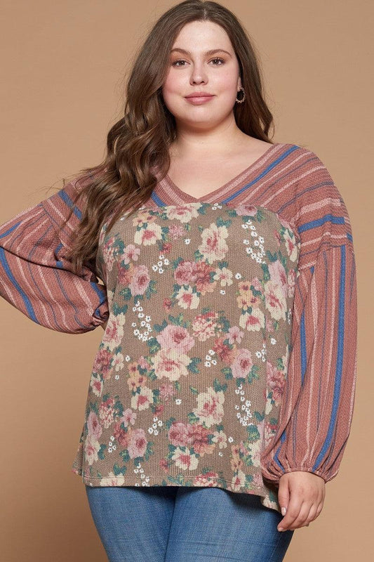 Plus-size woman wearing a floral printed knit top with long puffed sleeves, v-neckline, and striped yoke in marsala color.