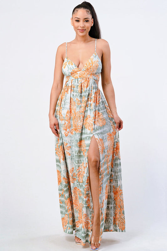 Floral printed side slit maxi dress with sleeveless design in orange and green tones, worn by a model. Made from polyester and spandex.