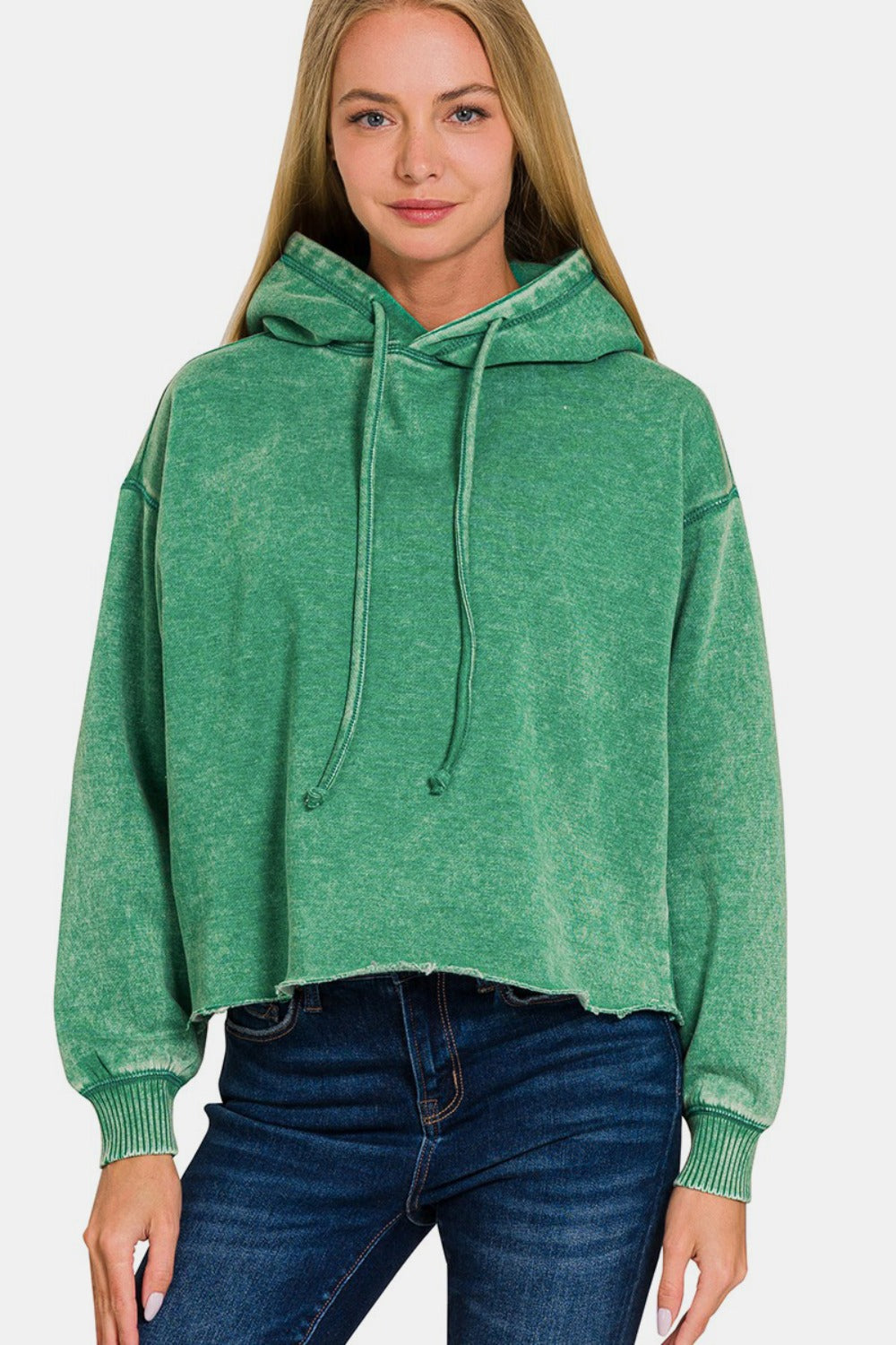 Woman wearing green Zenana Acid Wash Fleece Cropped Hoodie with jeans, showcasing trendy and cozy casual style.