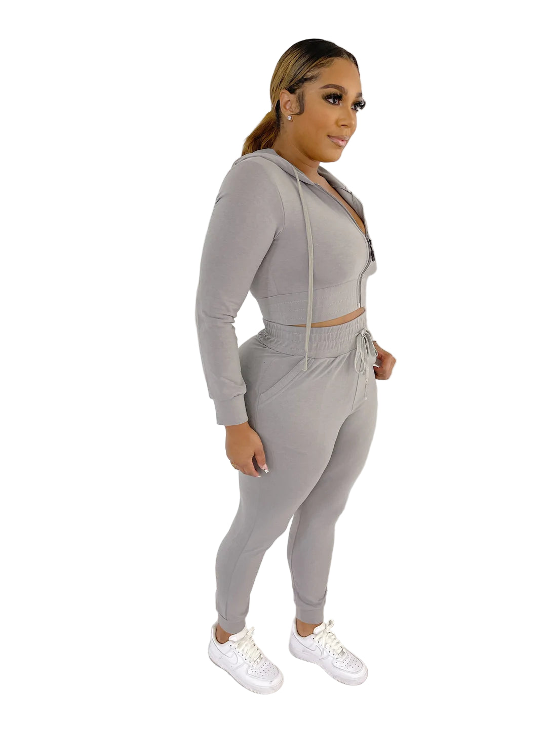 Woman wearing a stylish French Terry Jacket & Pants Set with drawstring, made of polyester and spandex, standing indoors.
