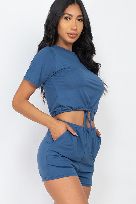 Woman wearing blue front tied crop top and shorts set made from soft Jersey fabric, perfect for casual summer wear.