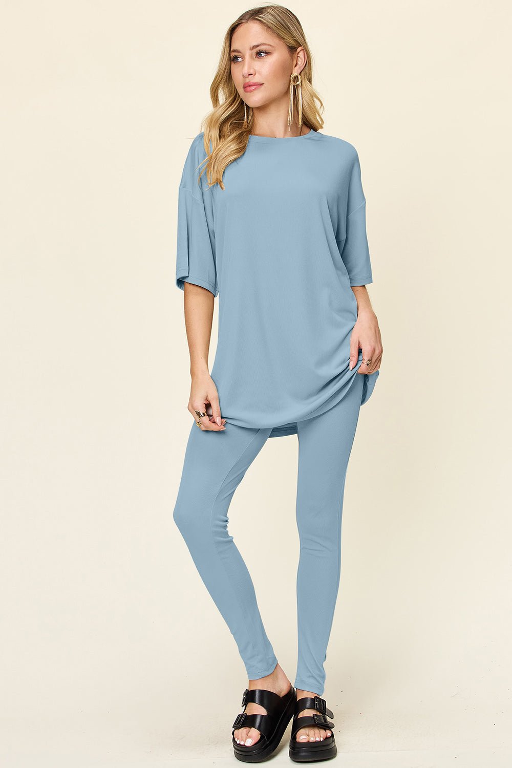 Woman wearing light blue double take full-size dropped shoulder t-shirt and leggings set, round neck, slightly stretchy fabric.