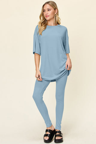 Woman wearing light blue double take full-size dropped shoulder t-shirt and leggings set, round neck, slightly stretchy fabric.