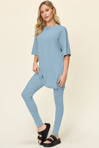 Woman wearing a light blue double take full size dropped shoulder t-shirt and leggings set with round neck and slightly stretchy material.