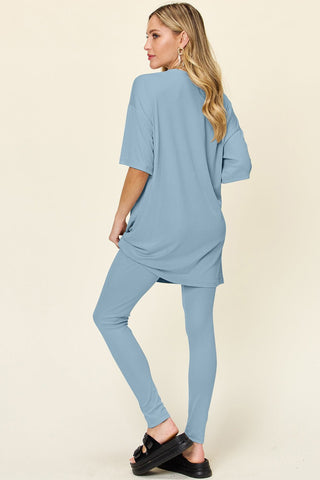 Woman wearing blue dropped shoulder T-shirt and leggings set, featuring a full-size, slightly stretchy fit made from polyester and spandex.