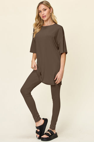 Woman wearing a brown dropped shoulder T-shirt and leggings set, featuring a round neck and slightly stretchy material blend.