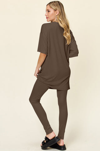 Woman wearing brown Double Take full-size dropped shoulder T-shirt and leggings set, featuring a round neck and slightly stretchy fit.