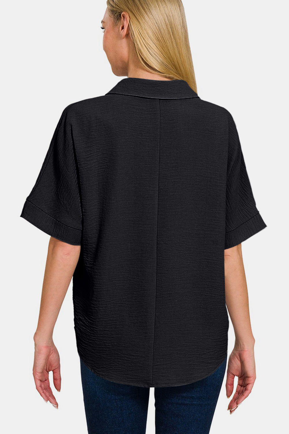 Woman wearing black full size texture collared neck short sleeve top, rear view, slightly stretchy polyester shirt.