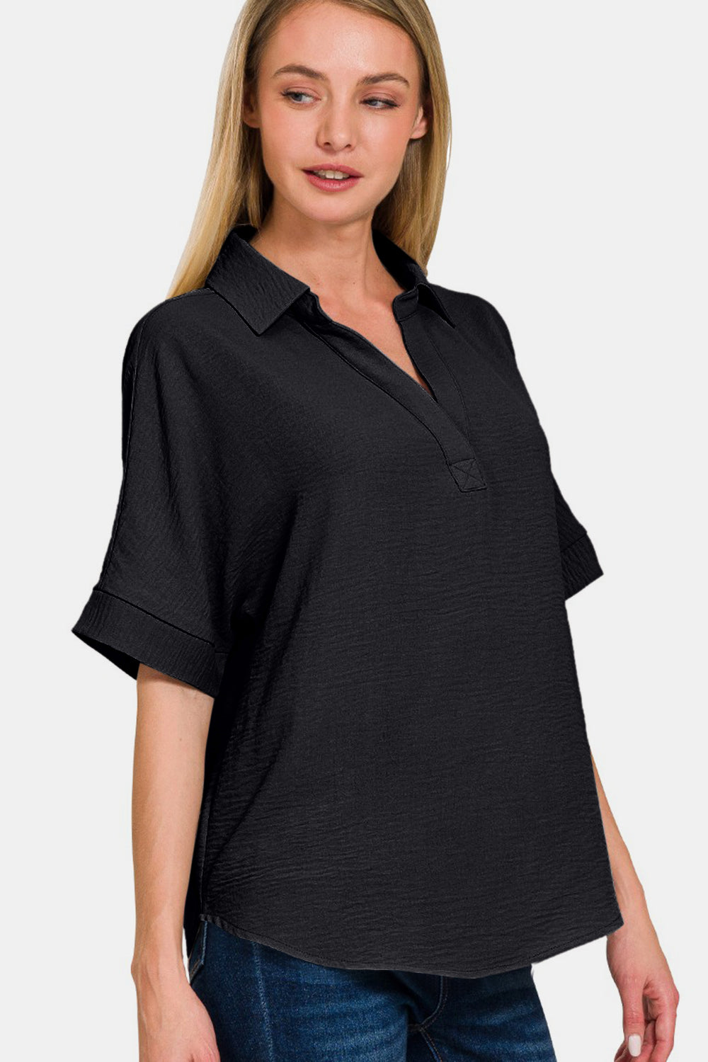 Woman wearing a full-size texture collared neck short sleeve top in black, made of 100% polyester, slightly stretchy and opaque.