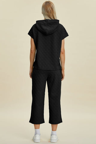 Back view of black short sleeve hoodie and pocketed pants set with drawstring, made of slightly stretchy polyester-spandex fabric.