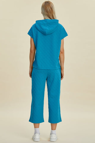 Woman wearing blue short sleeve hoodie and pocketed pants set, featuring drawstring and slight stretch, made of polyester and spandex.