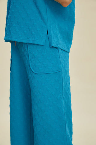 Blue textured short sleeve hoodie and pocketed pants set with drawstring detail, 95% polyester and 5% spandex.