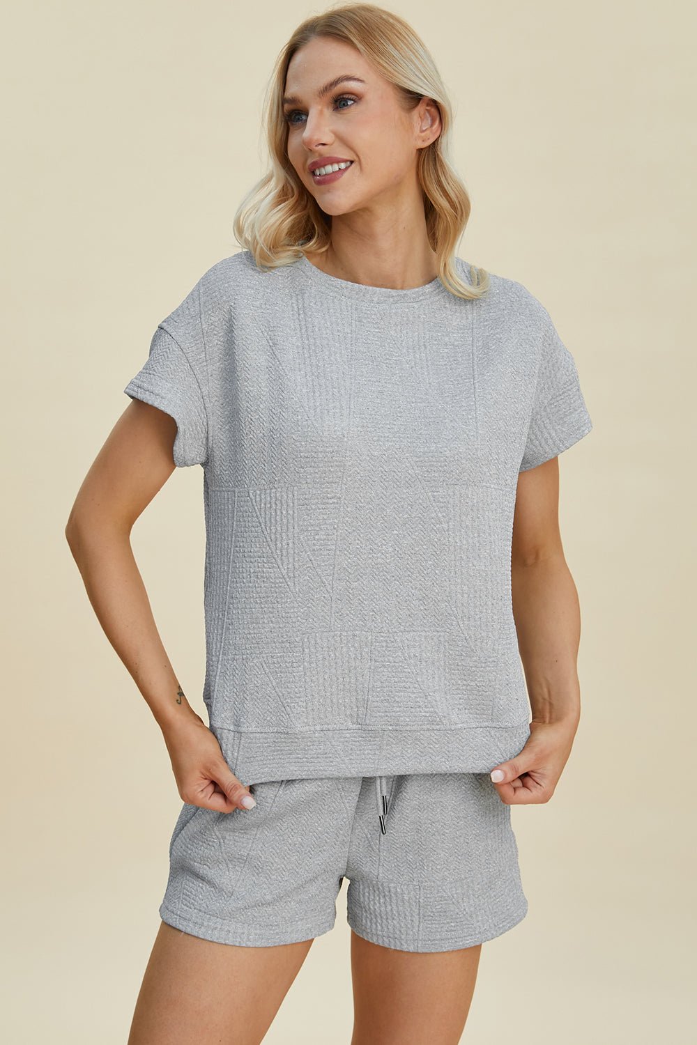 Woman wearing full size texture short sleeve top and shorts set with pockets and drawstring, slightly stretchy fabric.