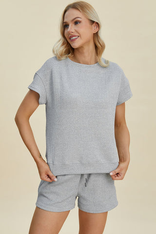 Woman wearing full size texture short sleeve top and shorts set with pockets and drawstring, slightly stretchy fabric.