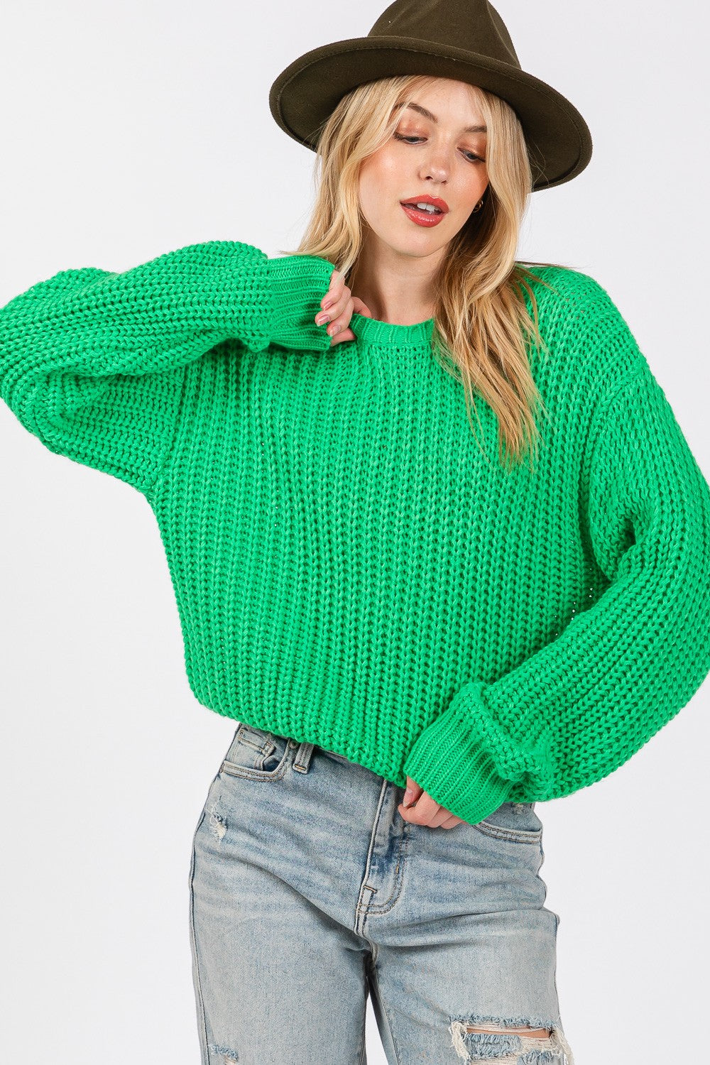 Woman wearing a green round neck drop shoulder sweater paired with a hat and jeans. Perfect for casual and stylish looks.