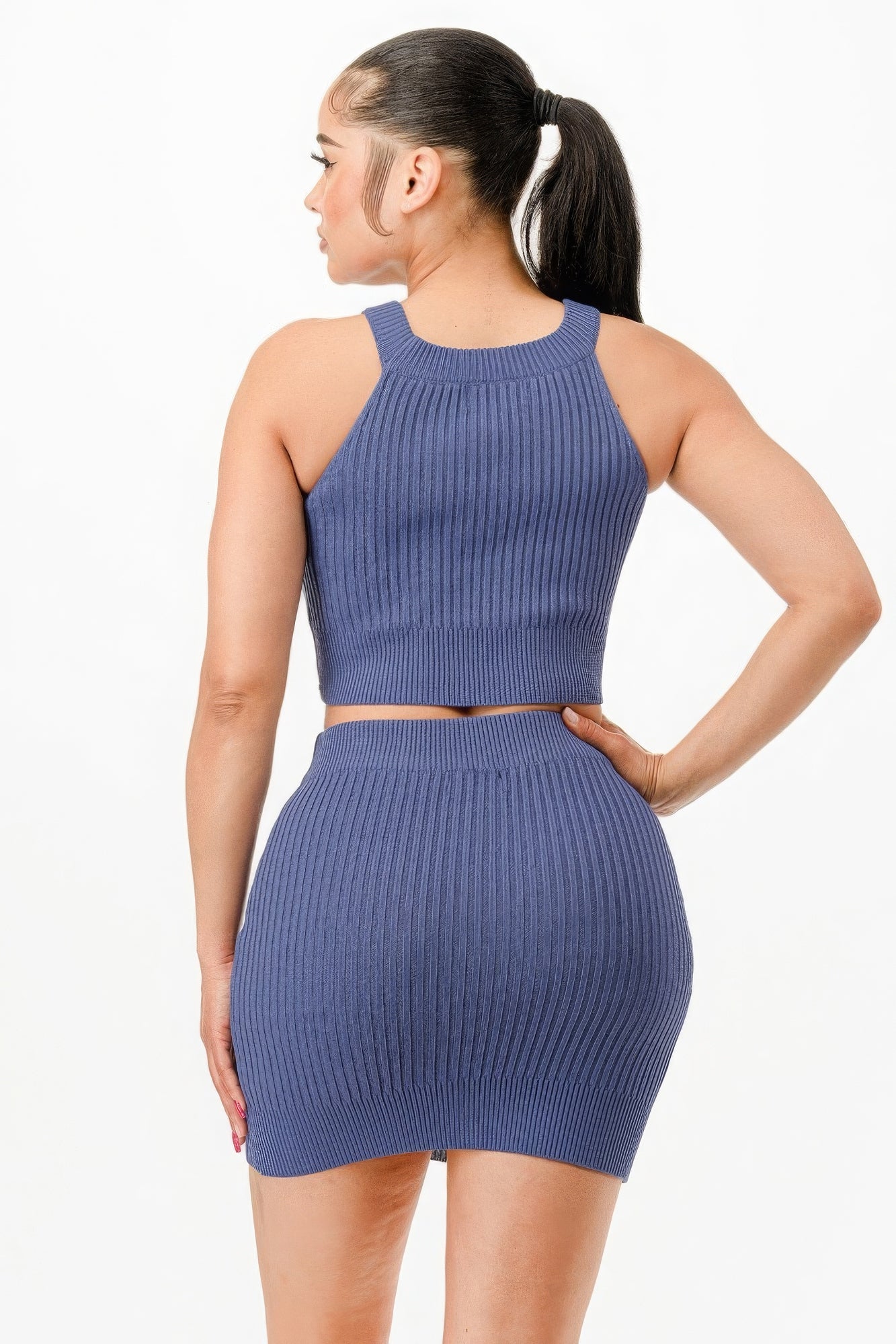 Woman wearing chic halter neck tank top and bodycon mini skirt set in solid color, showcasing a coordinated and sophisticated look.