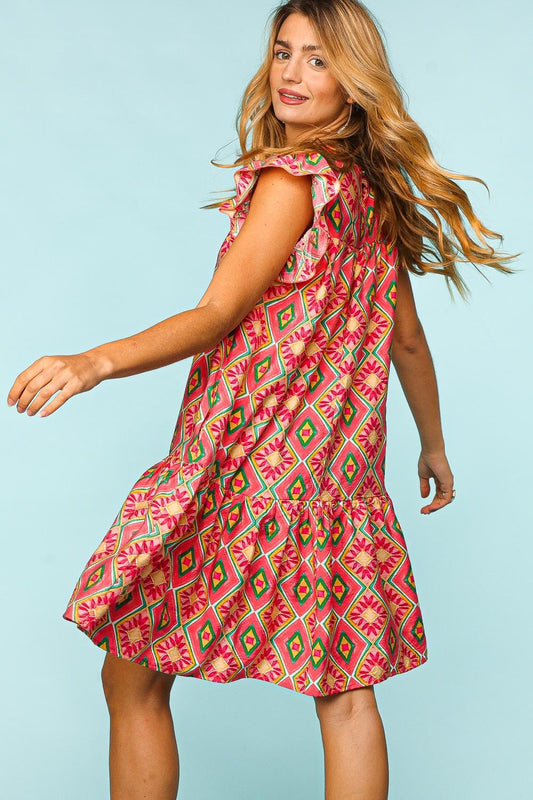 Woman wearing Haptics full-size ruffled printed dress with side pockets, featuring a vibrant geometric pattern and flowing design.