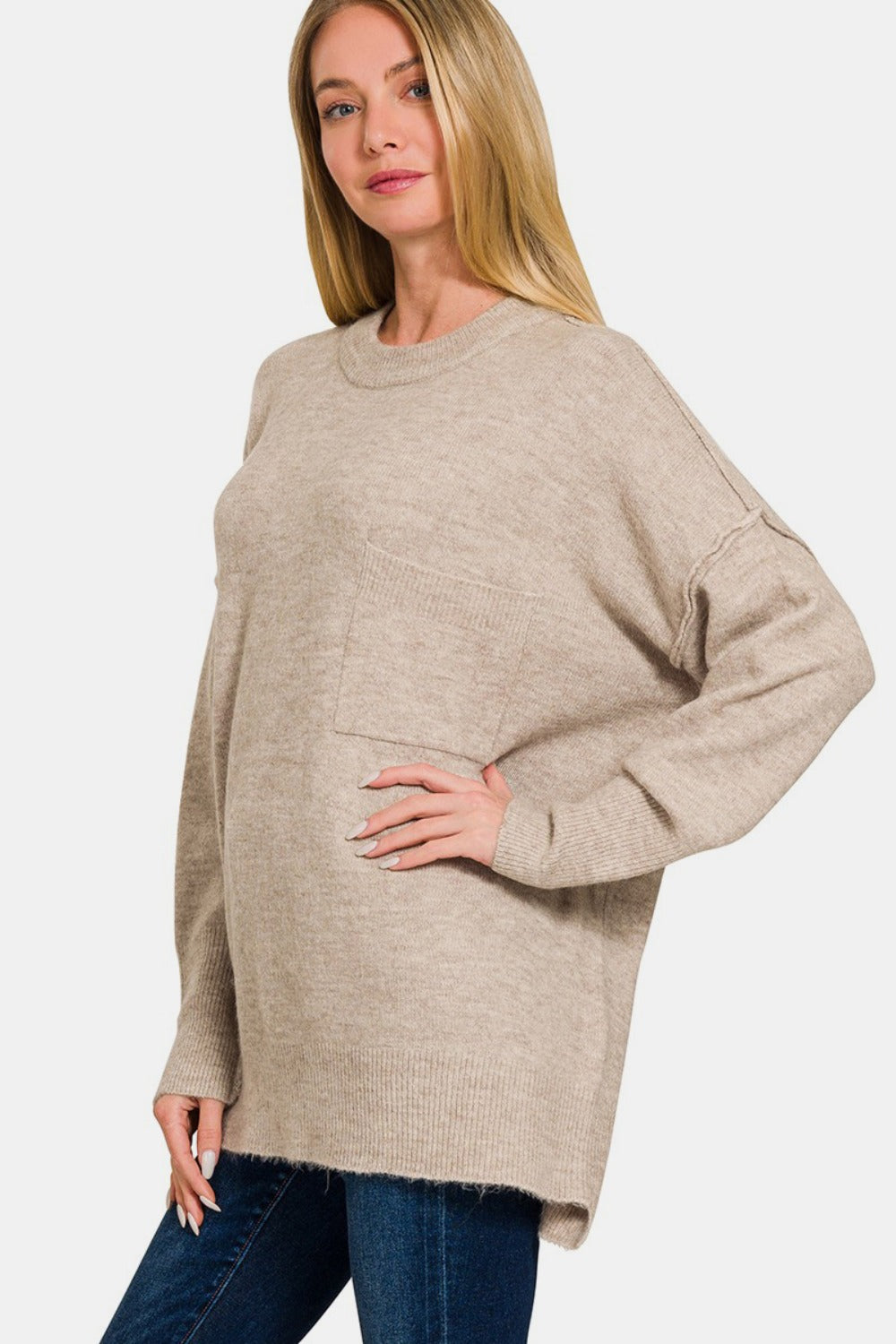 Woman wearing a beige high-low hem drop shoulder sweater with a comfortable and stylish design.