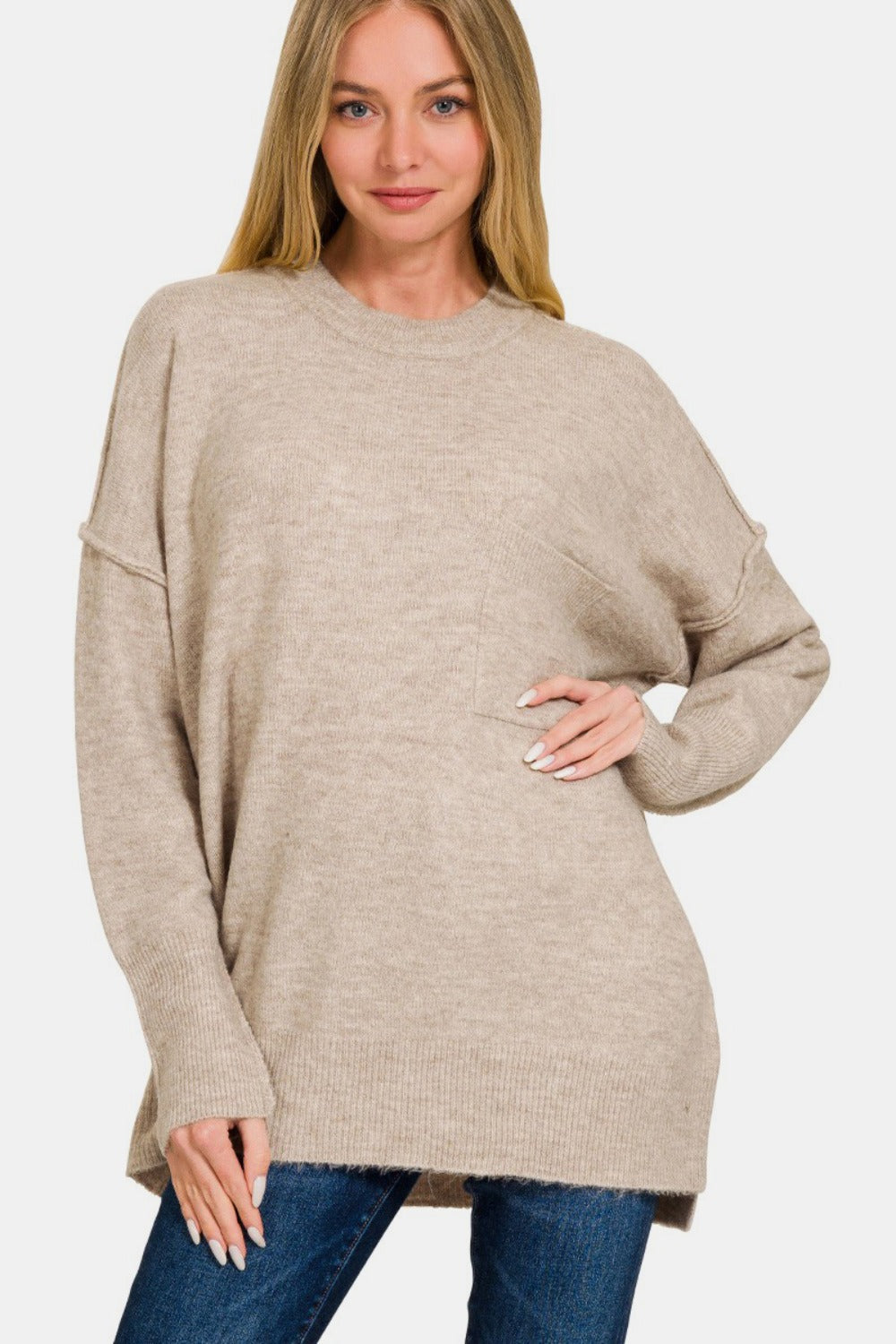 Woman wearing a high-low hem drop shoulder sweater in beige, showcasing cozy and stylish design for versatile fashion.