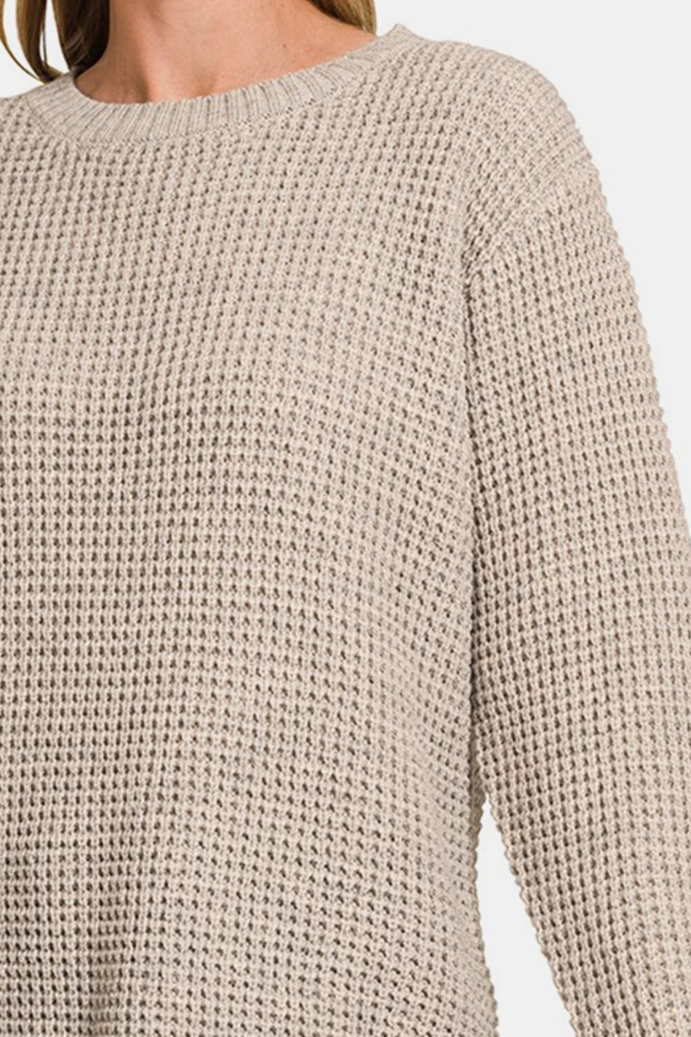 High low waffle-knit long sleeve sweater with moderate stretch made from 100% acrylic fabric.