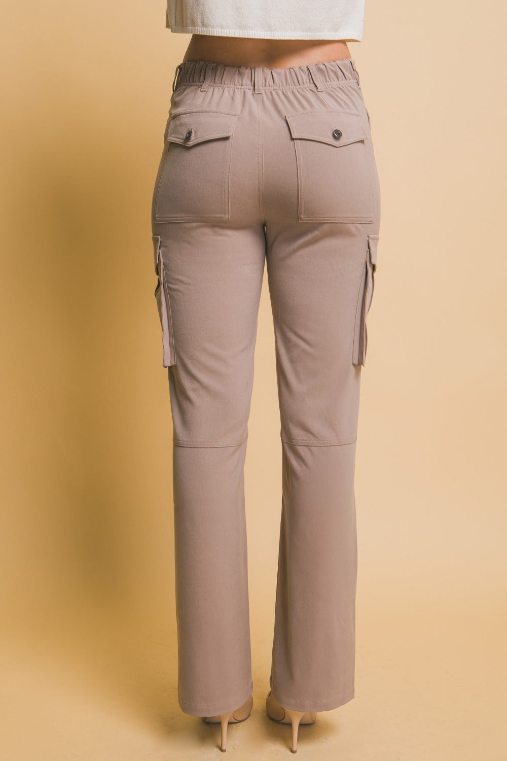 High rise cargo pants with practical pockets, shown from the back, highlighting relaxed fit and trendy utilitarian style.