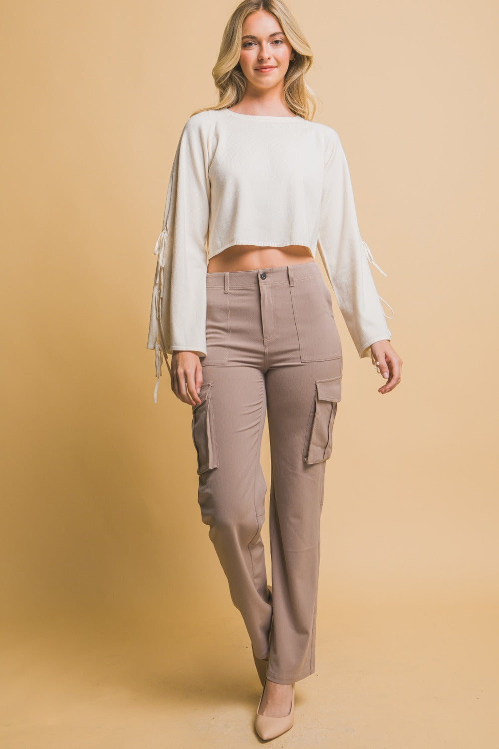 Woman wearing Love Tree High Rise Cargo Pants with pockets, paired with a cropped white top, showcasing a trendy and relaxed fit style.