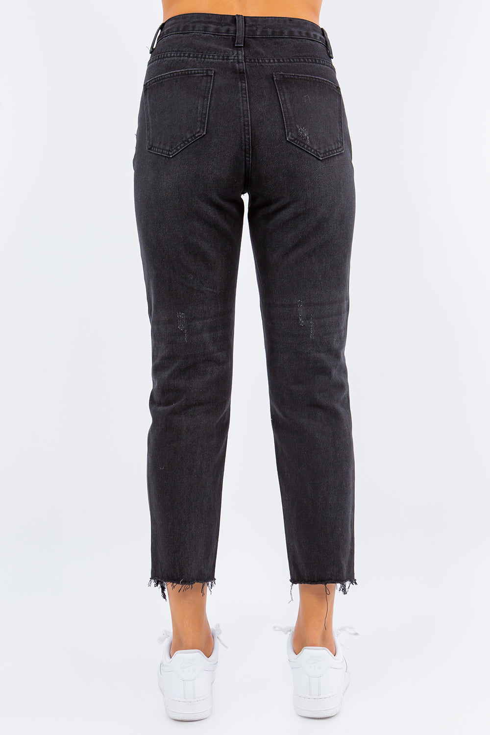 High waist distressed cropped straight jeans in black with raw hem, styled with white sneakers for a casual, chic look.