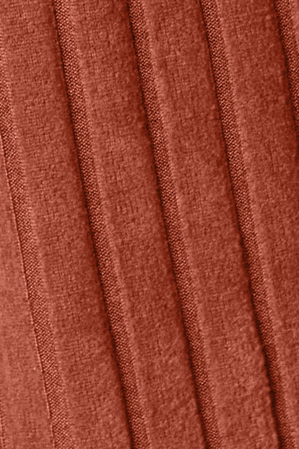 Close-up of a rust-colored fabric texture with vertical ribbed lines.