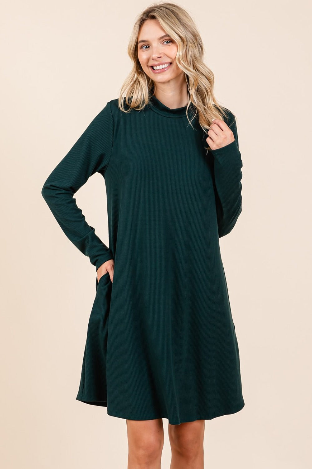 Hunter green mock neck long sleeve dress with pockets, slightly stretchy, made of polyester, rayon, and spandex.