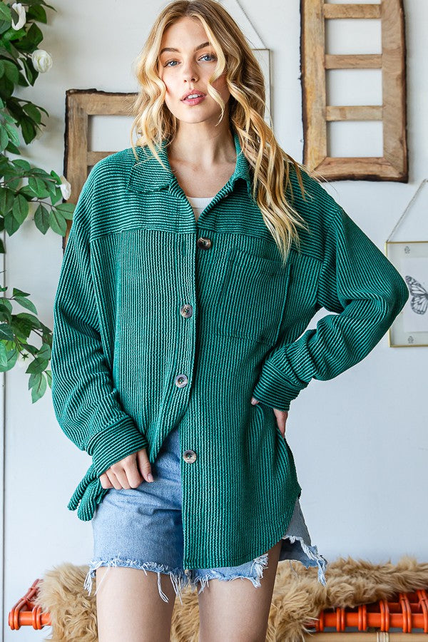 Woman wearing hunter green striped long sleeve shacket, styled with denim shorts, in a casual indoor setting.