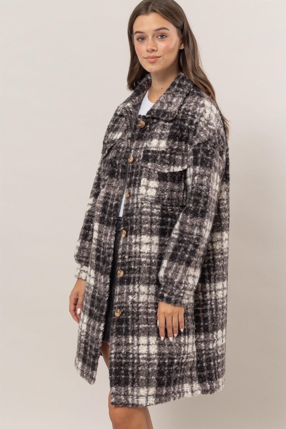 Woman wearing HYFVE plaid bouclé longline shacket with button-down front and chest flap pockets.