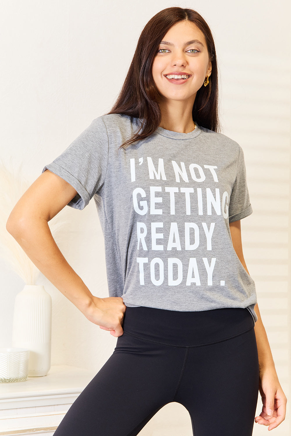 Woman wearing grey "I'M NOT GETTING READY TODAY" graphic T-shirt, comfortable and stylish for versatile casual wear.