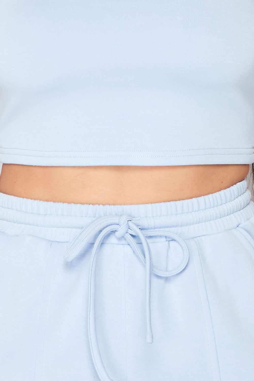 Light blue two-piece set with a crop top and drawstring waistband, made of rayon, polyester, and spandex for a comfortable fit.