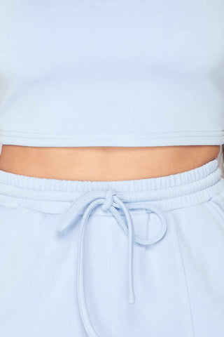 Light blue two-piece set with a crop top and drawstring waistband, made of rayon, polyester, and spandex for a comfortable fit.