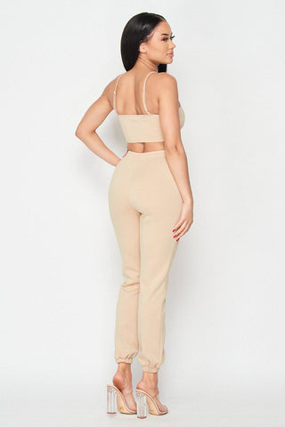Woman wearing Keep It Cute Two-Piece Set in beige, showing back view, featuring a crop top and joggers, stylish and comfortable outfit.