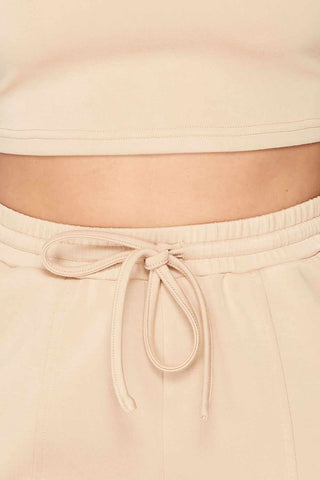 Beige Keep It Cute Two-Piece Set with cropped top and drawstring waist detail made from rayon, polyester, and spandex blend.