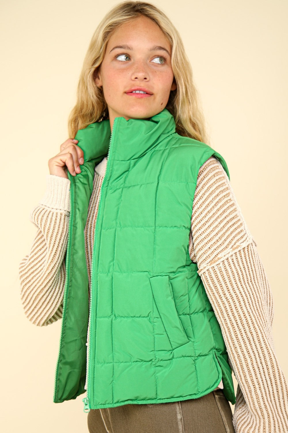 Woman wearing a Kelly Green quilted puffer vest, showing full-zip front and plush lining for warmth and style.