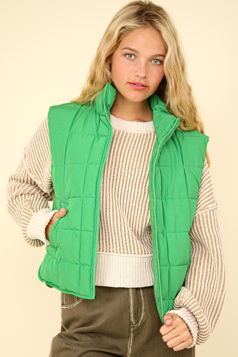 Woman wearing a Kelly Green quilted puffer vest with full-zip closure and stand collar for winter layering.